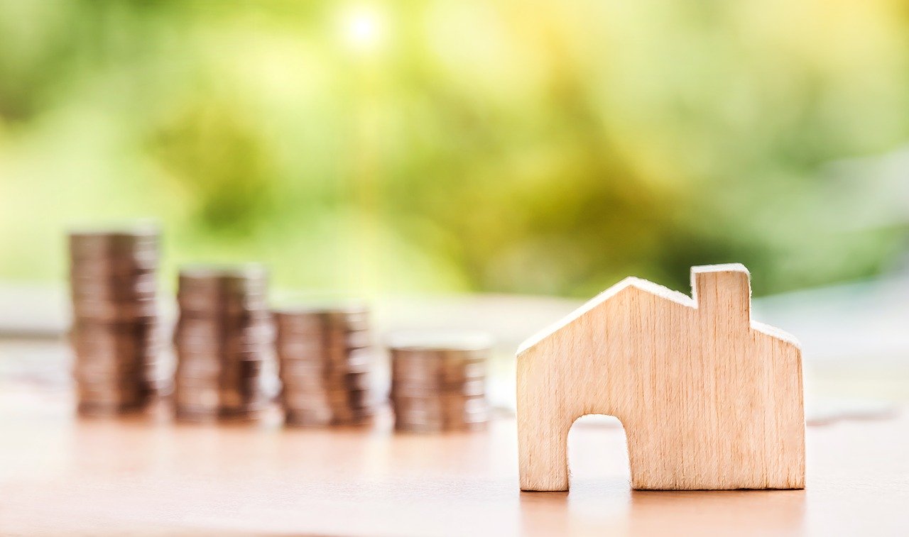 stacks of coin with wooden house