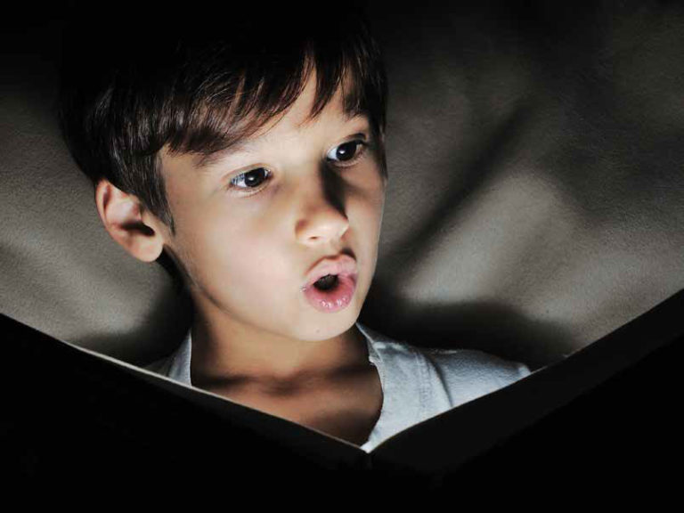 boy looking at glowing book surprised