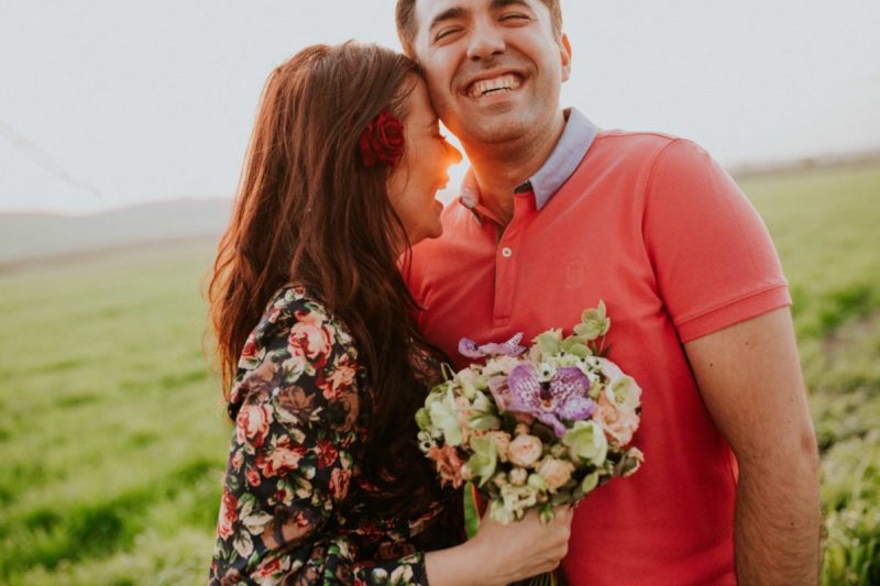 couple with flowers in hand in a field