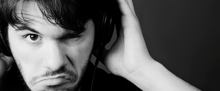 man with headphones on with grimace