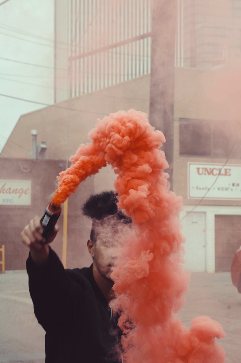 man holding red smoke