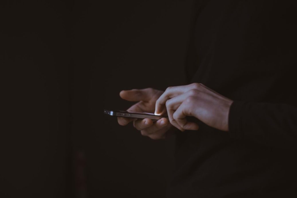 hands using iphone in the dark