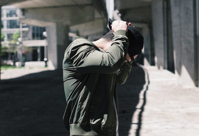 guy putting hat on backwards