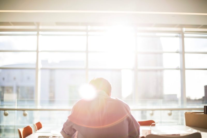 man sitting in front of a bright window