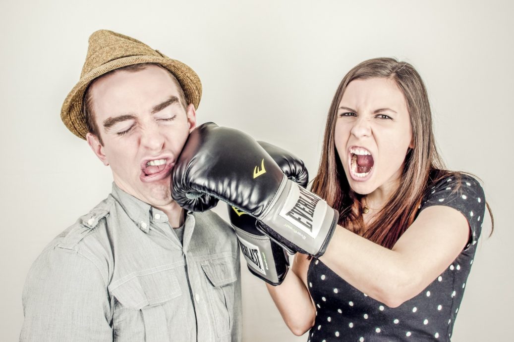 woman boxing her husband in a funny angry way