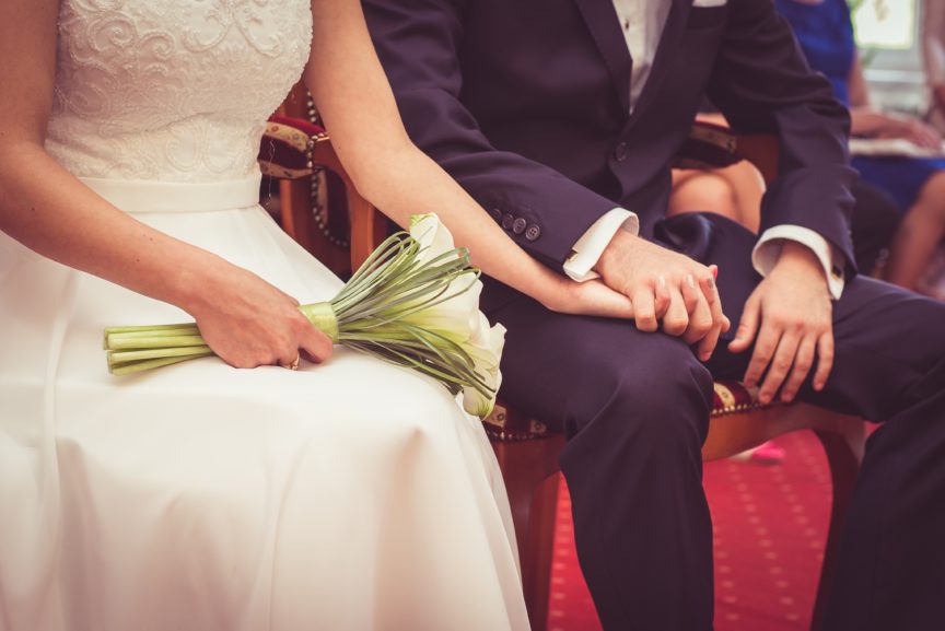 couple getting married sitting holding hands