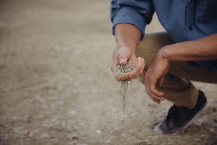man with sand slipping through his hands