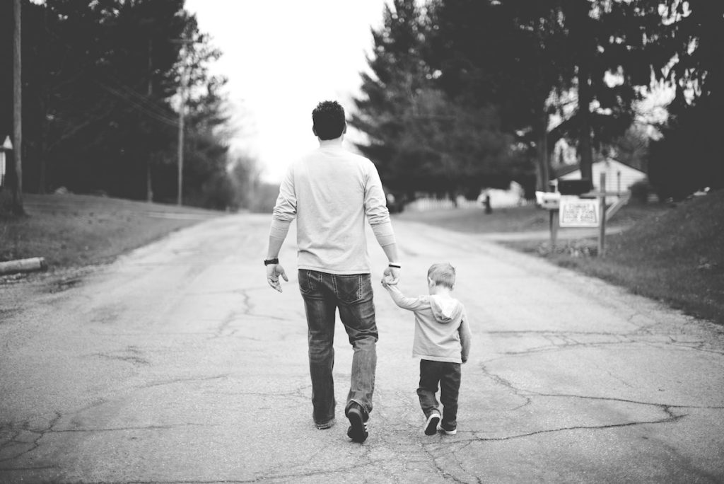 dad and son walking down street - black and white image