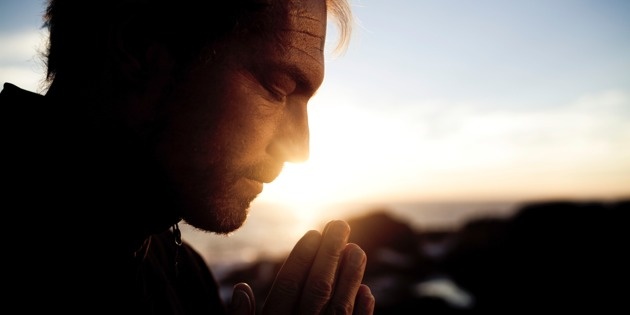 man praying at sunrise