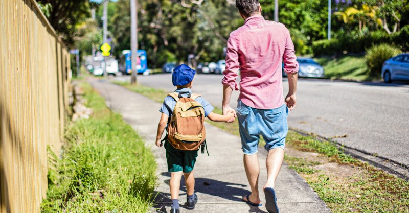 dad and boy walking to school