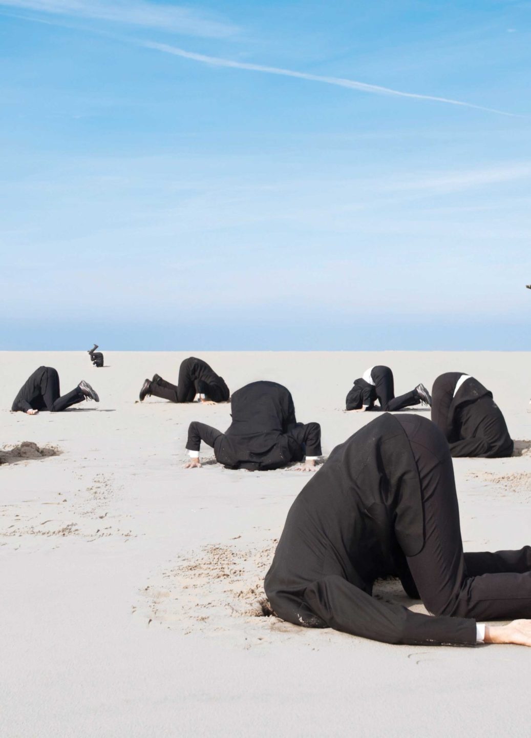 business people with heads in the sand