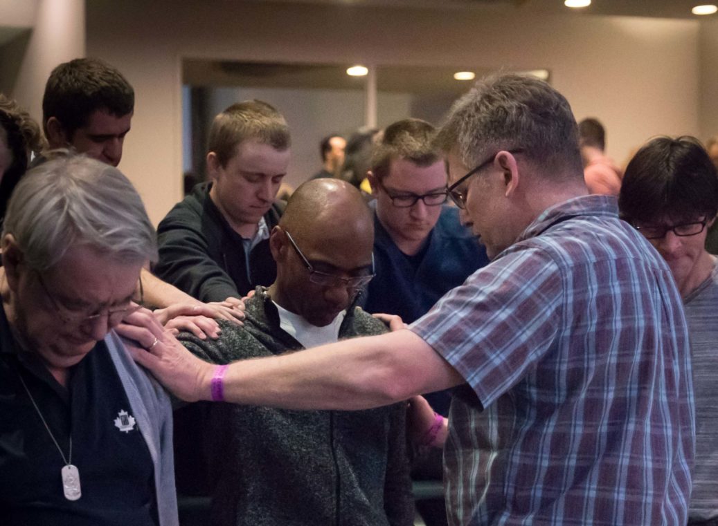 men praying at PK conference