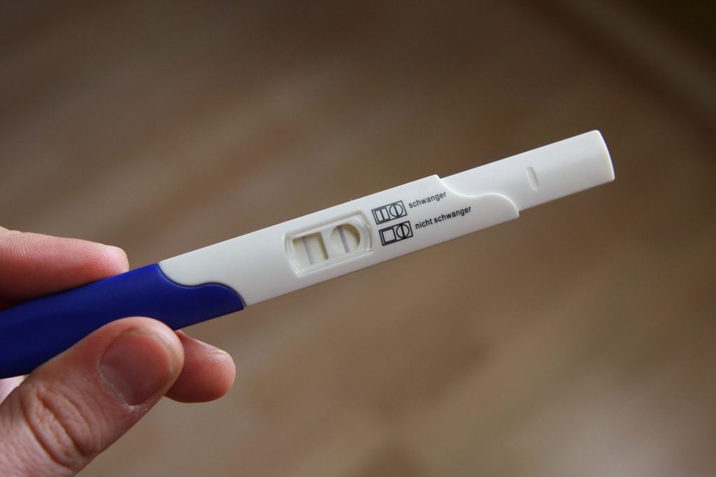 hand holding a positive pregnancy test