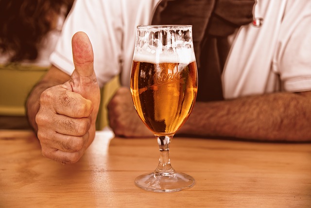 glass of beer with thumbs up from man