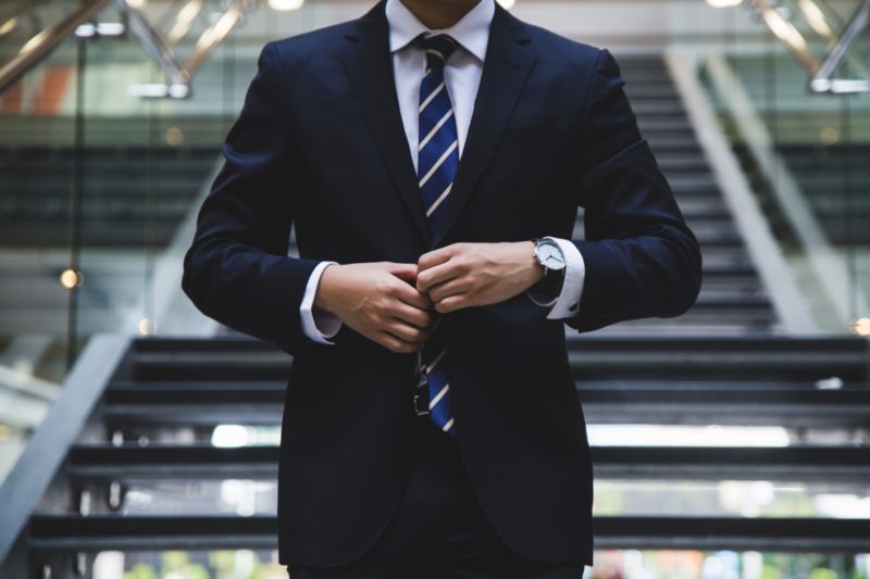 man buttoning up his suit jacket