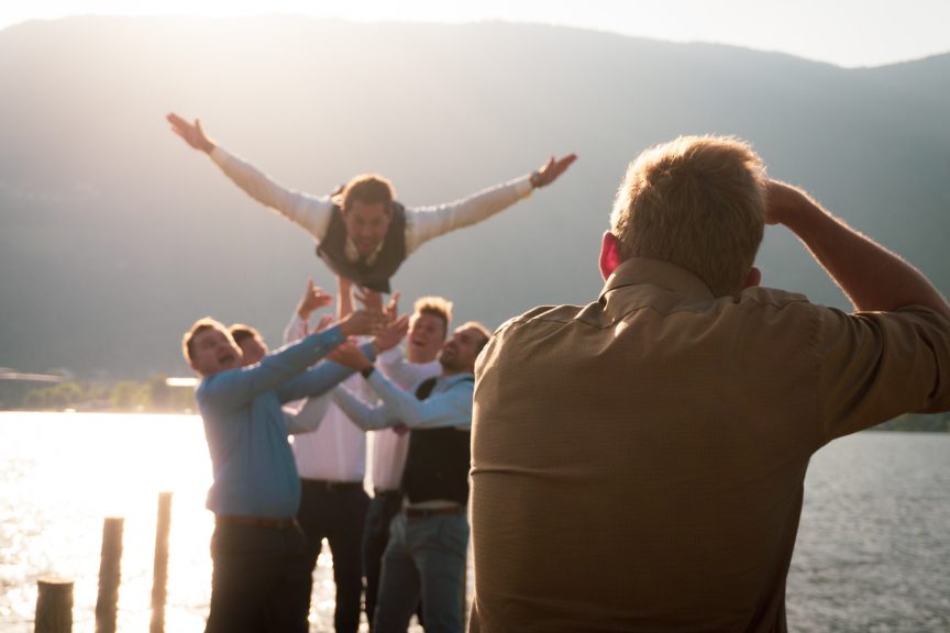 bachelor party throw groom into water from dock