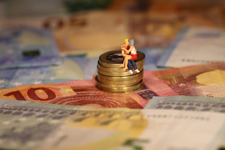 couple kissing on stack of coins