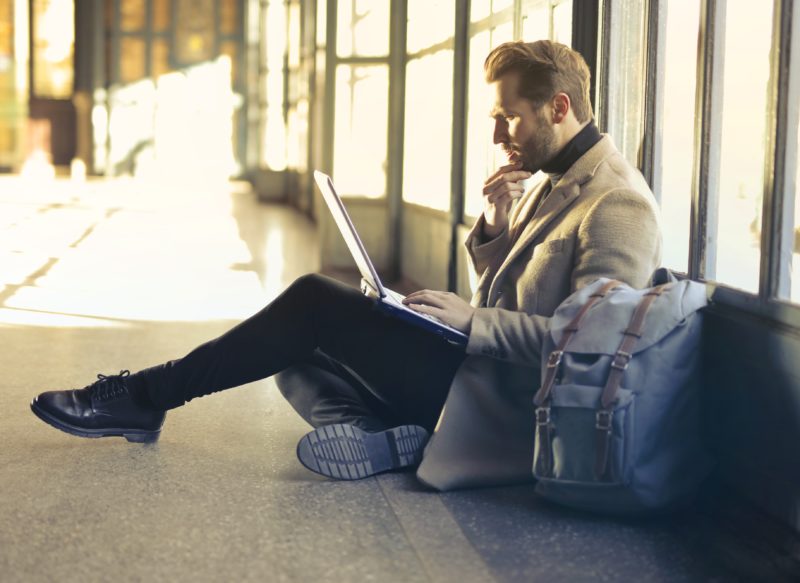 worried business man on laptop in airport