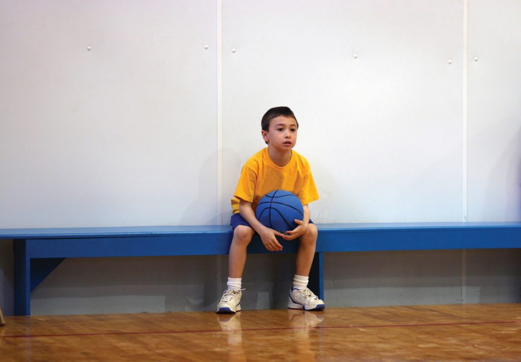 kid with basketball on the bench