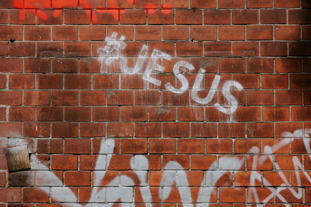 brick wall with #Jesus spray paint