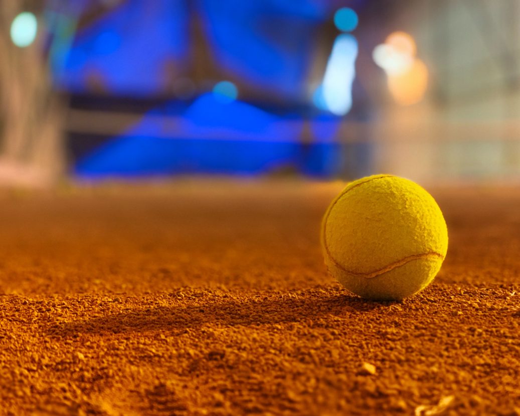 tennis ball on red orange dirt